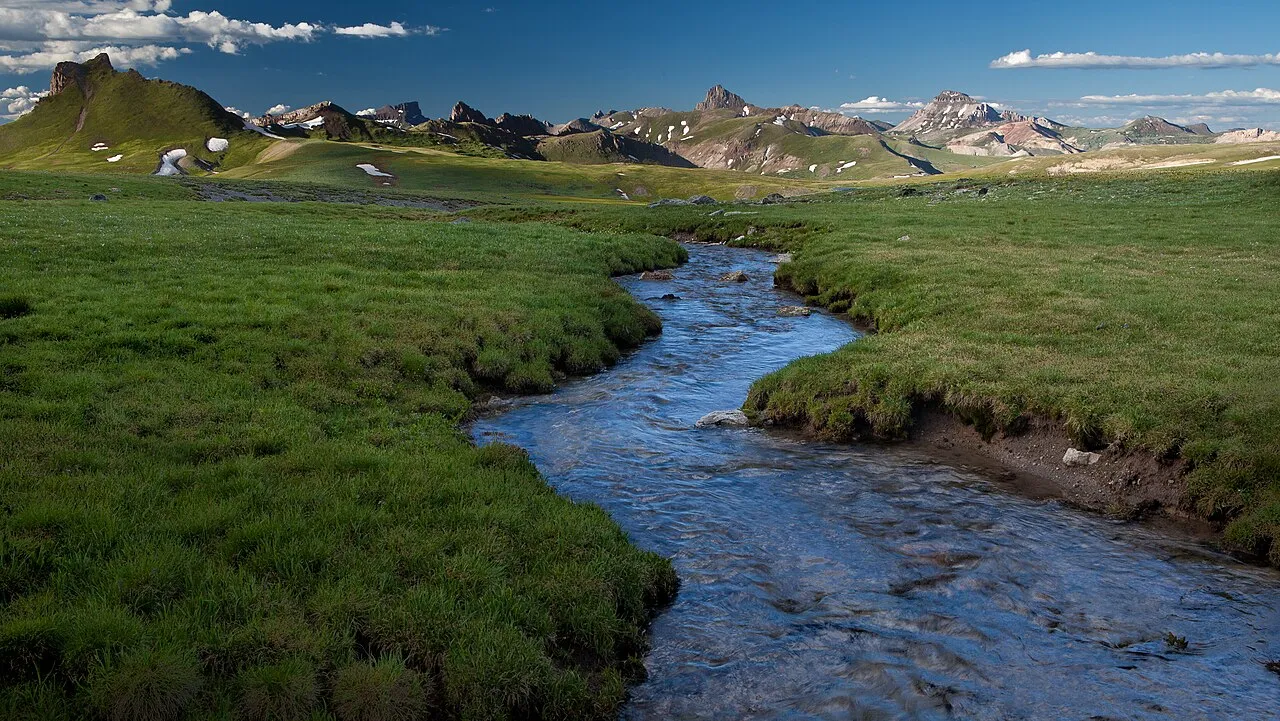 The Uncompahgre Wilderness in Colorado consists of gently rolling alpine tundra meadows, rugged, mountainous landscapes, and densely-forested canyons within the north-central San Juan Mountains. This wilderness boasts two ""fourteeners"" (on USFS-managed land) and more than 34 other peaks that tower over 13,000 feet in elevation. Visitors can explore over 100 miles of trails that provide excellent opportunities for various forms of recreation. Several forks of the Cimarron River roar through the