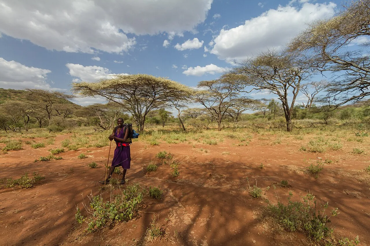 Masai chef "Grand Paul" posing in the middle of a red savannah landscape.